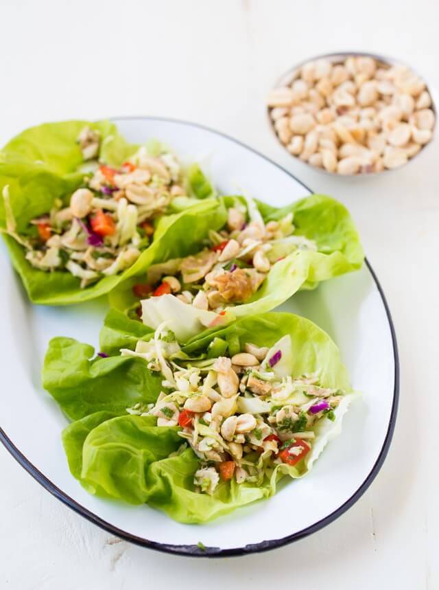 three lettuce wraps filled with meat, peanuts and veggies
