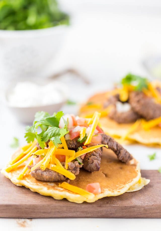 close up of steak, parsley and cheese on top of a corn filled pancake