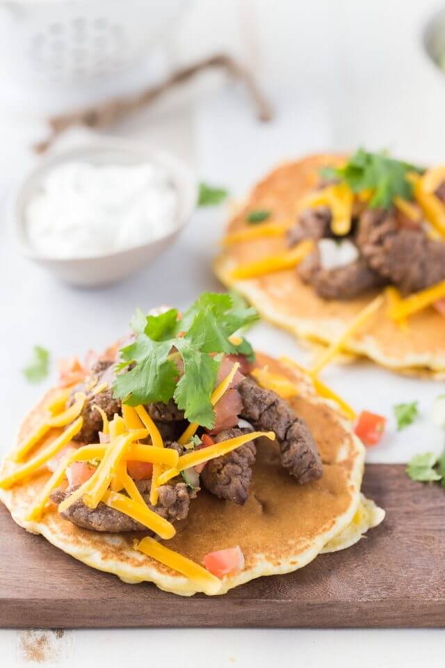 steak, parsley and cheese on top of a corn filled pancake