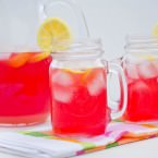 cranberry lemonade drink in a pitcher and two mason jar glasses