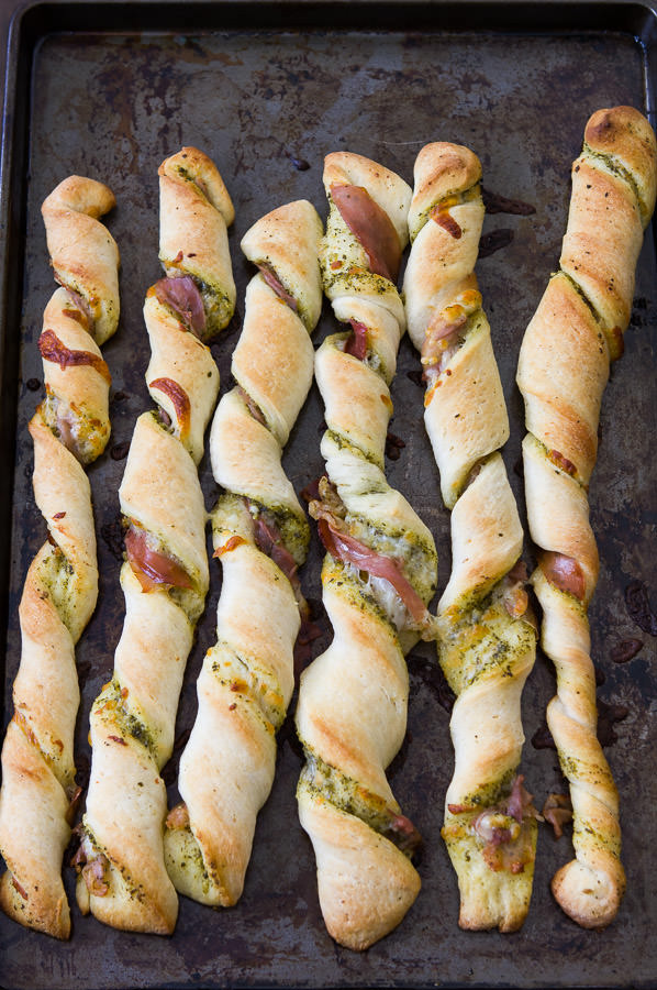 pizza twists lined up on a baking sheet