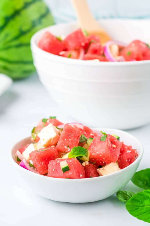 watermelon salad in a small bowl in front of a bigger white bowl