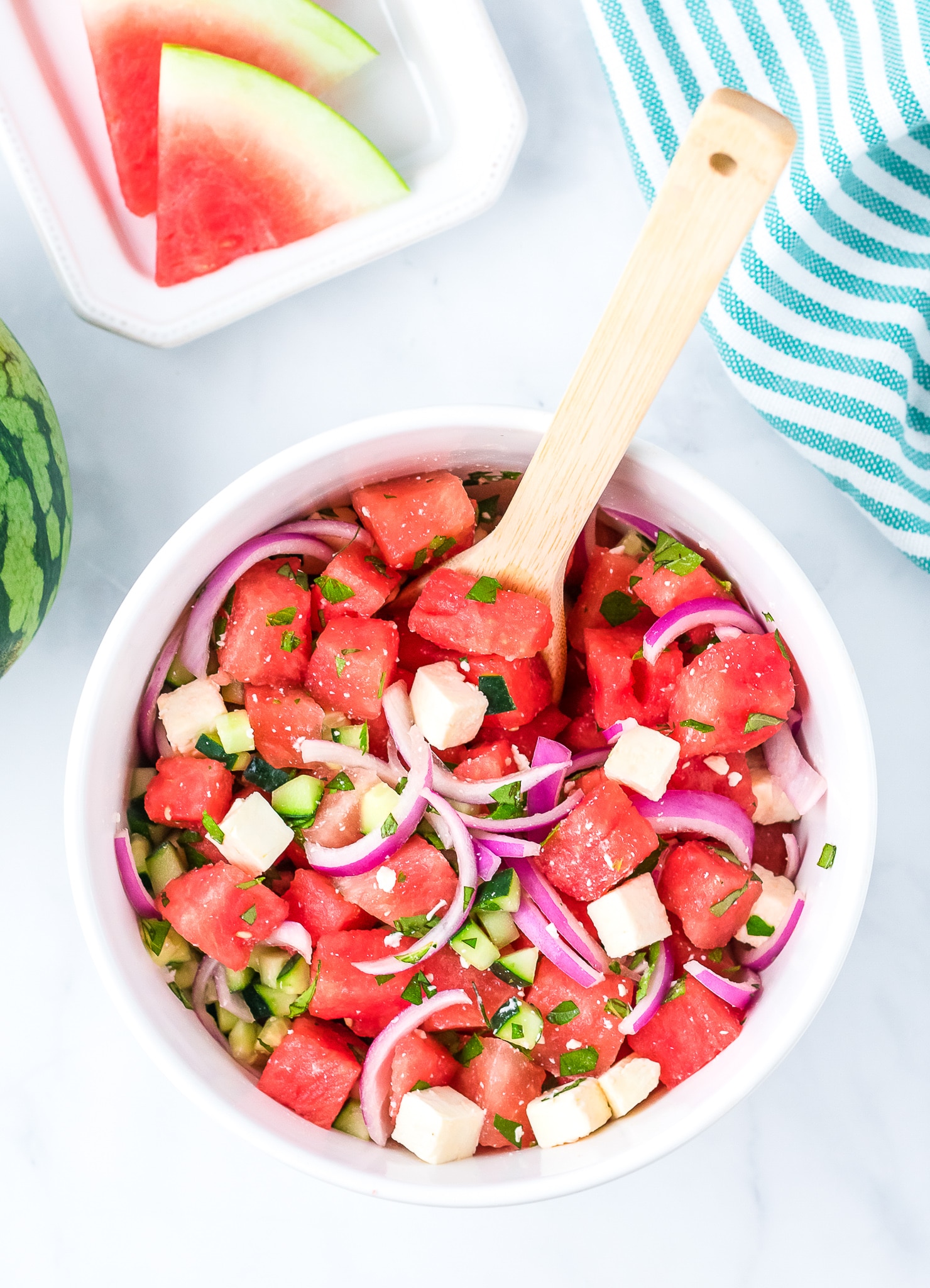 watermelon, red onion, and mint in a bowl with a spoon