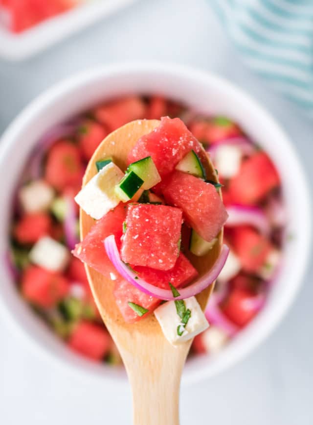 a close up of this watermelon salad on a wooden spoon