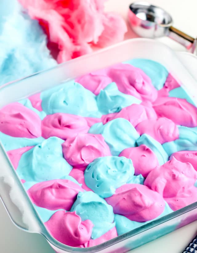 a batch of pink and blue ice cream in a dish ready to be frozen