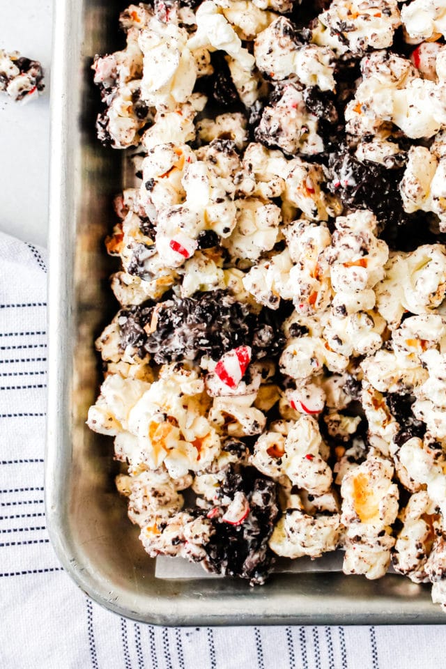 a close up of popcorn, chocolate, candy, and cookies on a tray